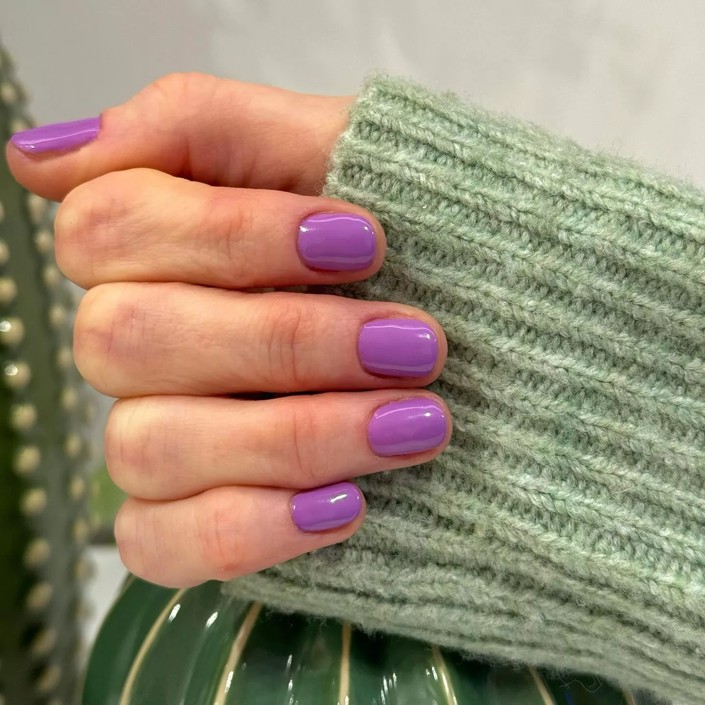 Uñas de la mano con tratamiento de manicura en color violeta