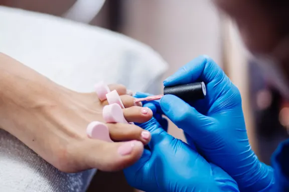 Persona pintando las uñas de los pies