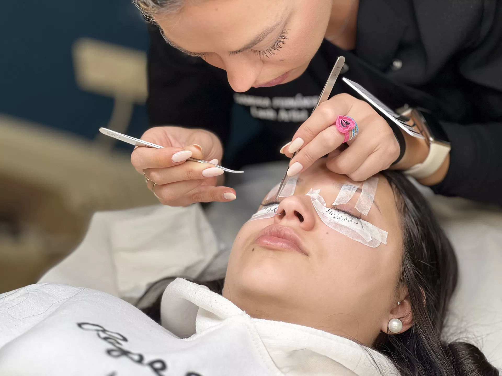 Mujer realizando tratamiento de pestañas a otra mujer